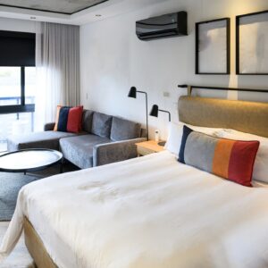 Contemporary hotel room interior with a king bed and a clean minimalist layout